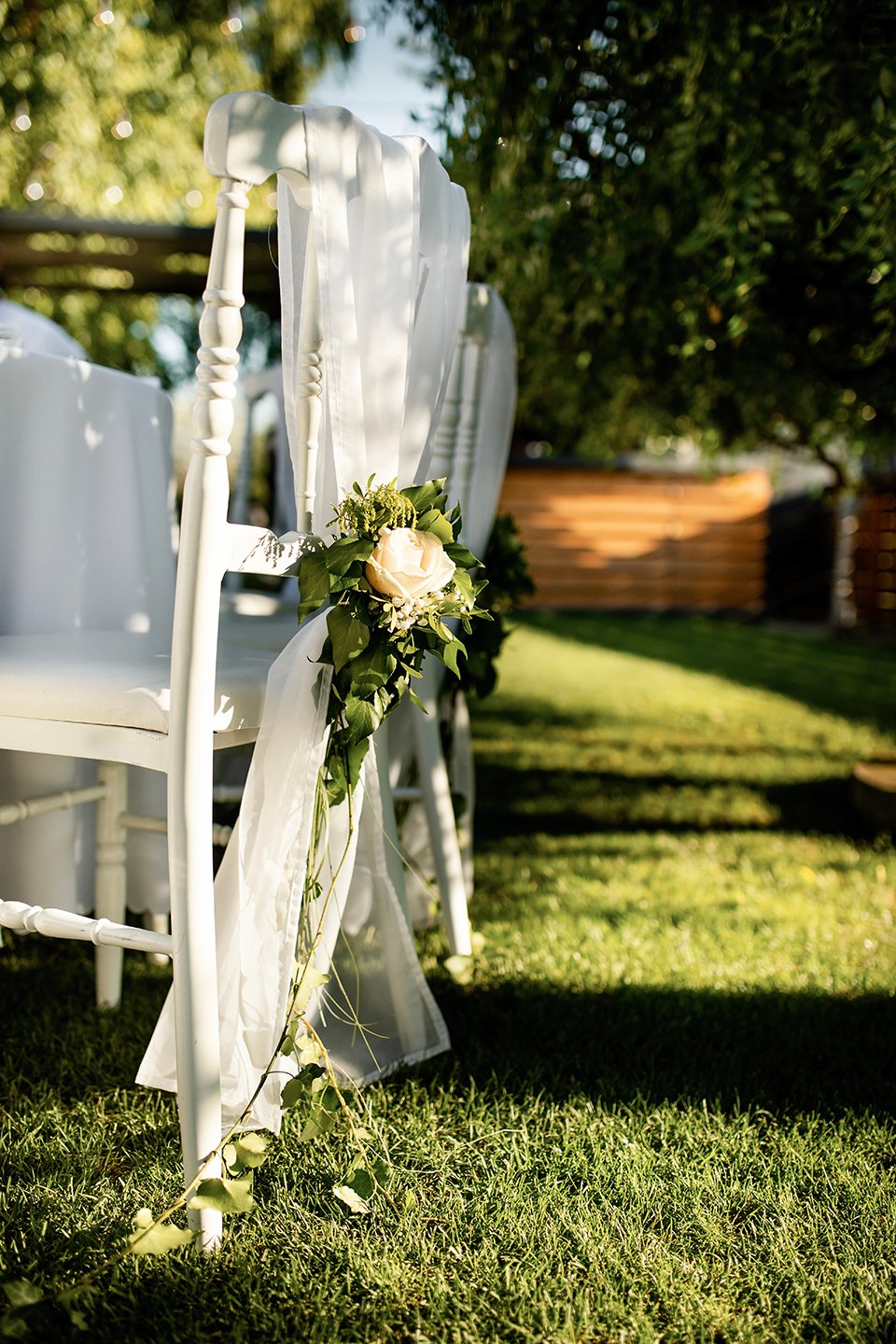 Decorated white chair at wedding reception.